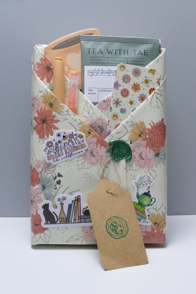 Wrapped book with tea, and bookish accessories